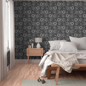 Modern bedroom with floral wallpaper, wooden bed, and side table.