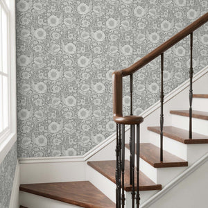 Staircase with wooden steps and a floral patterned wallpaper.