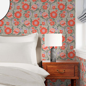 Bedroom with floral wallpaper, bed, and wooden nightstand.