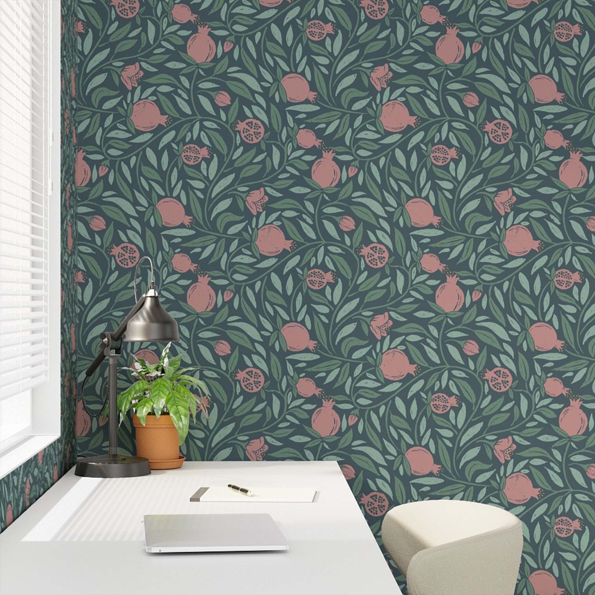 Woodcut Pomegranate fruit and leaves on dark teal background closeup in a desk nook